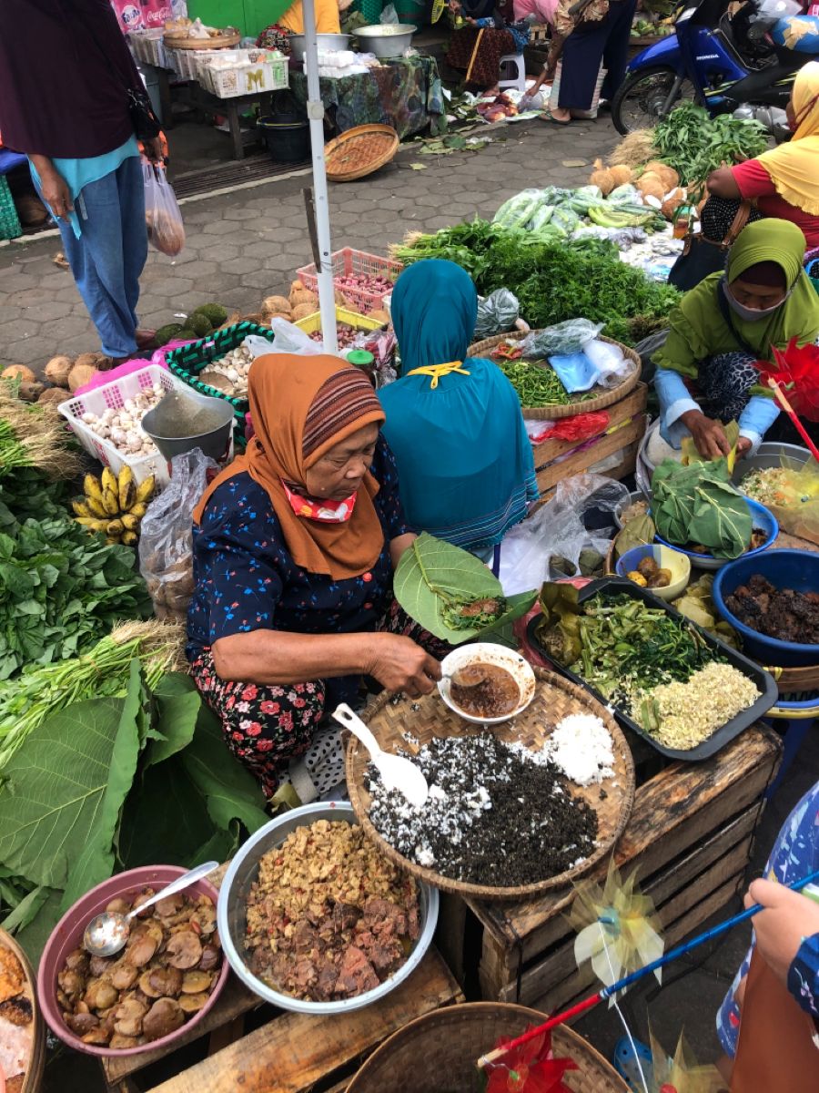Vendors selling fresh produce and snacks at a market